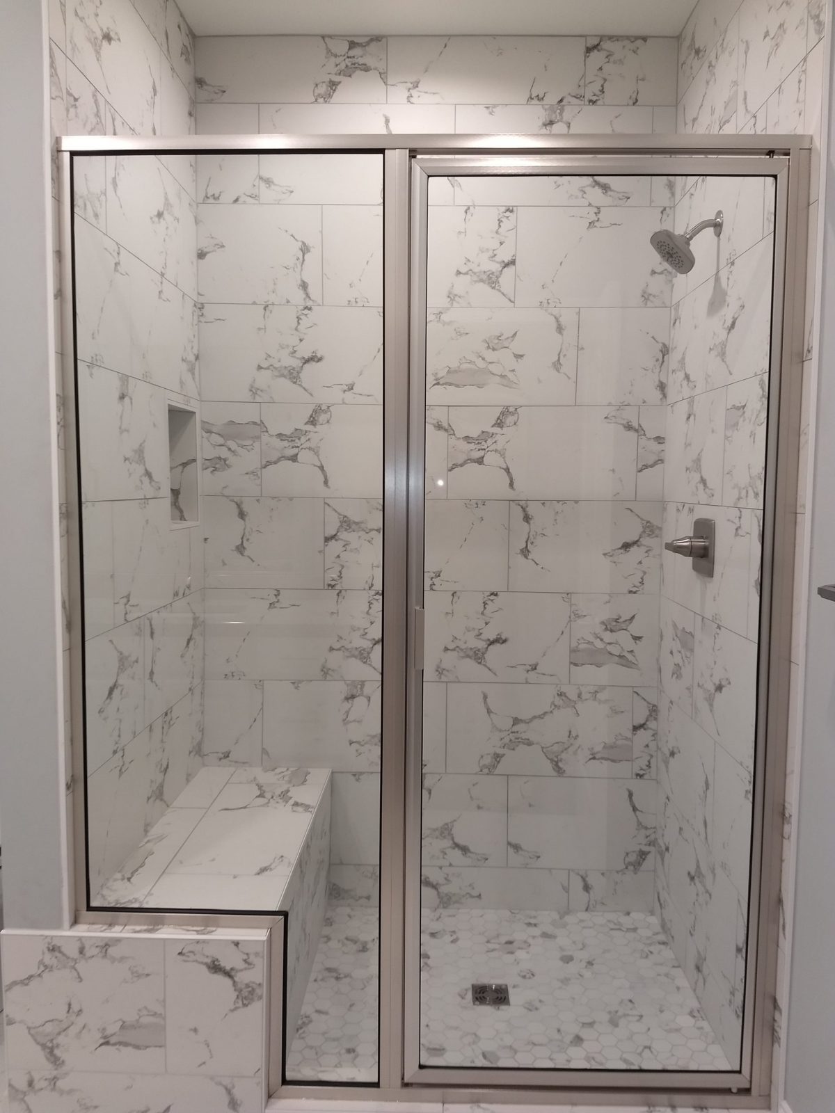 new shower with a seat lined with white granite tile