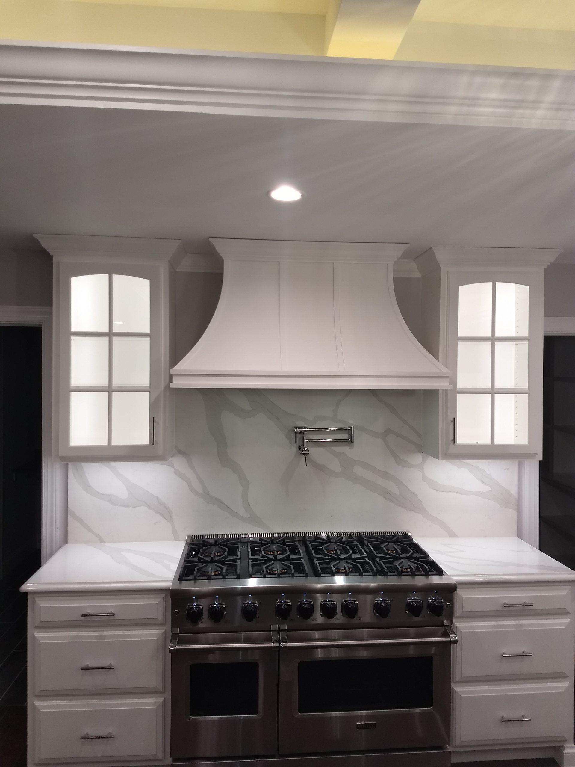 new stove with a white smoke catcher and white cabinets