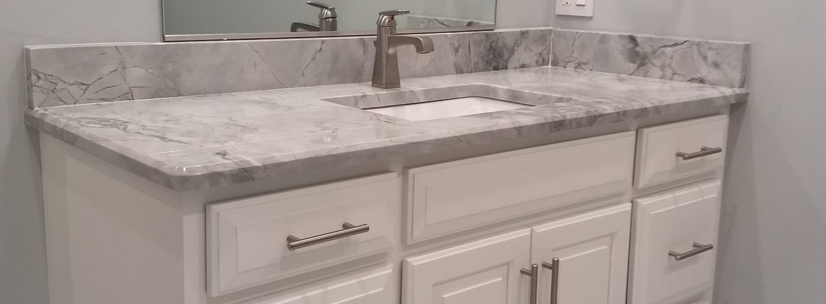 new grey granite counter sink with white cabinets and grey walls